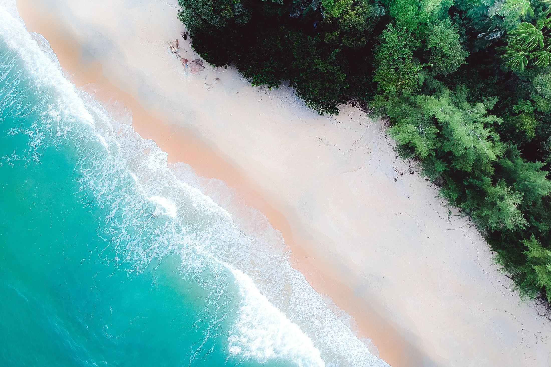 Aerial view of surf meeting a white-sand Bahamian beach